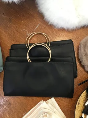 Black folding clutch with gold hoop straps