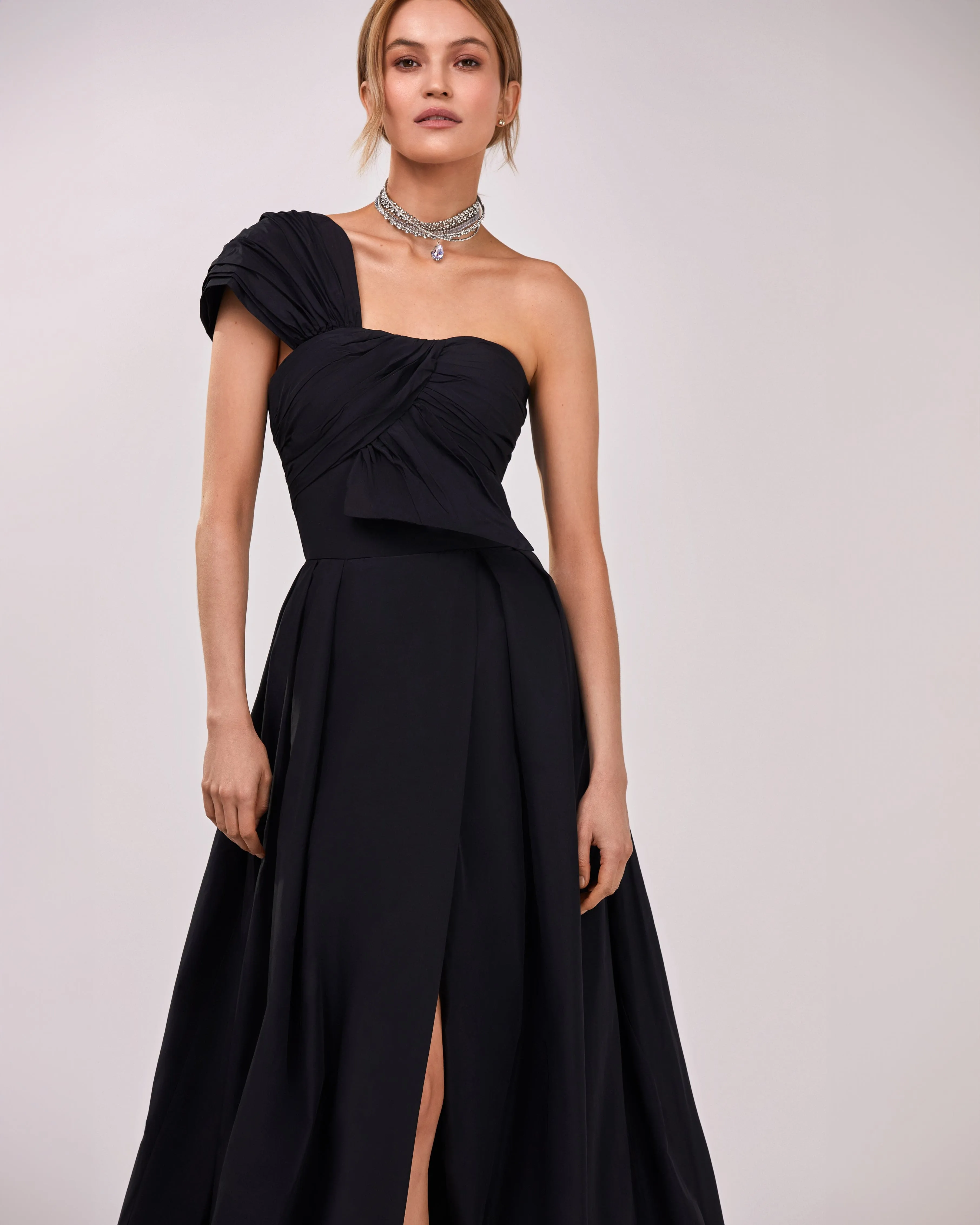 Black taffeta evening gown with a high slit and one-shoulder wrap top